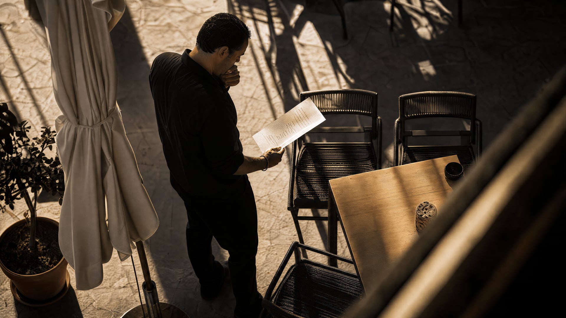 Mallorca restaurant owner reviewing proposed anti-smoking rules beside an outdoor terrace
